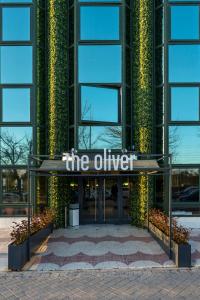 ポスエロ・デ・アラルコンにあるThe Oliver Apartamentosのオリバーを読む看板のある建物