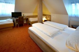 a room with two beds and a desk with a computer at Hotel Gasthof zum Biber in Motten