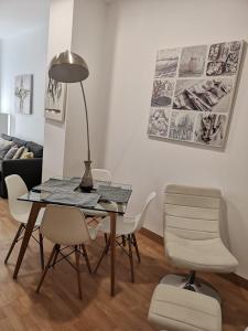 jadalnia ze stołem, krzesłami i lampką w obiekcie ALC - Apartamento céntrico en calle Mayor w Alicante