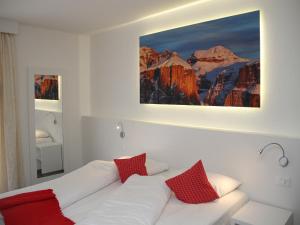 a living room with a white couch with red pillows at Fedaia Joy B&B in Canazei +263 photos