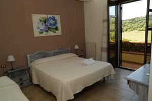 a bedroom with two beds and a balcony at Agriturismo La Petrosa in Ceraso