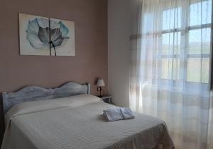 Ceraso的住宿－拉佩多薩假日農莊酒店，一间卧室设有一张床和一个窗口