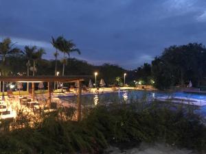 a swimming pool at night with chairs and lights at Flat 4 Suites Hotel Portal Gravata in Gravatá