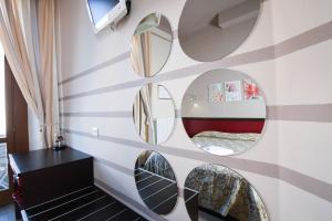 a room with circular mirrors on a striped wall at Bergamo Romantica in Bergamo