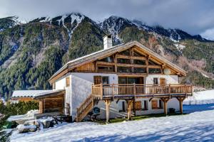 a log cabin in the snow with mountains in the background at Chalet Tissières in Chamonix