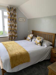 1 dormitorio con 1 cama grande con sábanas y almohadas blancas en Chy an Gwedhen, en St Ives