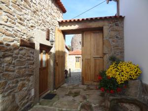 einen Eingang zu einem Steingebäude mit einer Holztür in der Unterkunft Casas do Juizo - Country Houses in Juizo