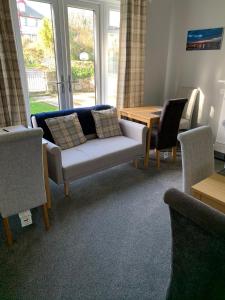 uma sala de estar com um sofá, cadeiras e uma mesa em Chy an Gwedhen em St Ives