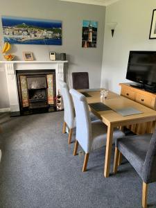 a dining room with a table and chairs and a fireplace at Chy an Gwedhen in St Ives