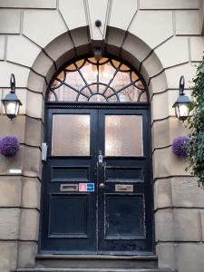 una puerta negra en un edificio con dos luces en Carnegie Library: Bronte Apartment 1 bedroom en Swinton