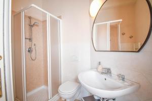 W łazience znajduje się toaleta z umywalką i lustro. w obiekcie Bergamo Romantica w Bergamo +11 zdjęć