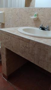 HOTEL PUERTA DEL SOL في سانتو دومينغو دا لوس كولورادوس: منضدة الحمام مع وجود مغسلة في الحمام