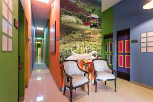 un corridoio con due sedie e un tavolo con un dipinto sul muro di Parceros Med Hostel a Medellín