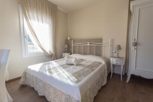 a white bedroom with a bed and a window at Antica Dimora Stucky in Treviso