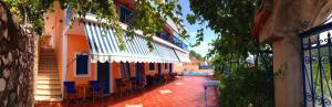an alley with tables and chairs next to a building at Maria Studios in Agia Effimia