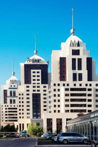 - un grand bâtiment blanc avec deux dômes au-dessus dans l'établissement Radisson Hotel Astana, à Astana