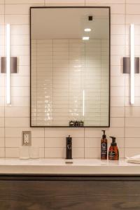 W łazience znajduje się lustro i umywalka. w obiekcie Hew & Draw Hotel w mieście Corner Brook