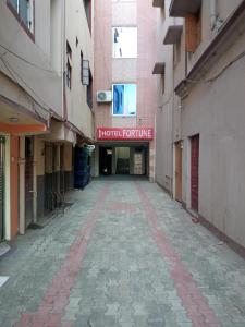 un callejón vacío con una señal de admisión de hotel en un edificio en Hotel Fortune, en Patna