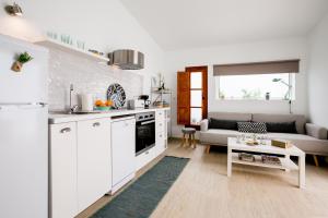 a kitchen with white cabinets and a living room at Cactus Apartment in San Miguel de Abona