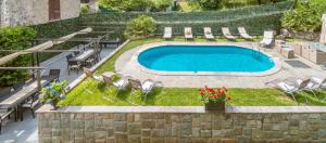 a swimming pool in a yard with chairs and a table at The Lake Como Villa in Menaggio