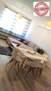 uma sala de estar com uma mesa branca e cadeiras em Hatvan Corner Apartments em Debrecen