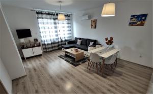 salon z czarną kanapą i stołem w obiekcie Hatvan Corner Apartments w Debreczynie