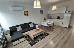 a living room with a couch and a table and a kitchen at Hatvan Corner Apartments in Debrecen