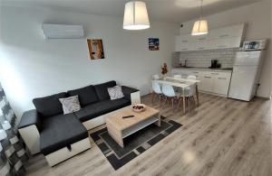 salon z kanapą i stołem oraz kuchnia w obiekcie Hatvan Corner Apartments w Debreczynie