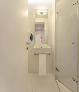 a white bathroom with a sink and a shower at Lisbon Serviced Apartments - Madalena in Lisbon