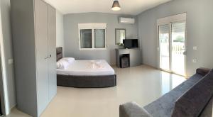 ein Schlafzimmer mit einem Bett, einem TV und einem Sofa in der Unterkunft Vila Chelsea in Ksamil