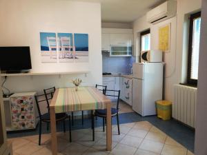 a kitchen with a table and chairs and a refrigerator at Apartments Mare Losinjska 16 in Rabac