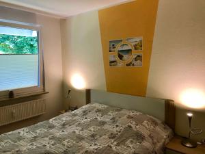 Schlafzimmer mit einem Bett und einem Fenster in der Unterkunft Ferienwohnung Waldblick in Glücksburg