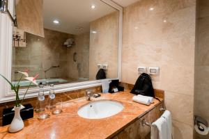 a bathroom with a sink, mirror, and bathtub at Hotel Melia Lima in Lima