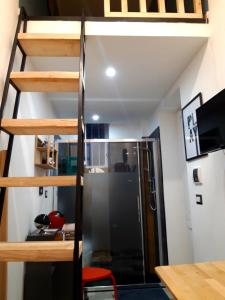 a loft bed in a small room with a refrigerator at Metro Station Mini Van CAPSULA House in Turin