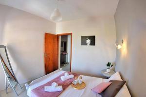 Calma Luxury Apartments #2 Sozopoli in Halkidiki في سوزوبولي: غرفة نوم عليها سرير وفوط