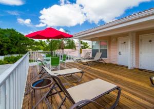 a deck with chairs and a red umbrella at Tropical Beach Resorts - Sarasota in Sarasota