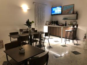 un restaurante con mesas y un bar con TV en la pared en Residence Alle Scuole Country House, en Granarolo dell'Emilia