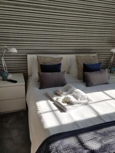 - une chambre avec un grand lit blanc et un mur rayé dans l'établissement Bragas Studios, à Porto