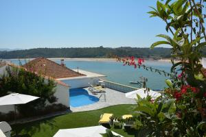 a resort with a pool and a view of the water at Apartamentos Cintra do Vale in Vila Nova de Milfontes