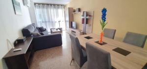 un salon avec une table et une fleur bleue dans un vase dans l'établissement Fantástico apartamento al lado del Serrallo, à Tarragone