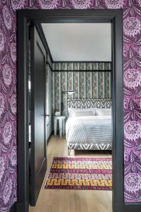 a bedroom with a bed and a purple wall at San Francisco Proper Hotel, a Member of Design Hotels in San Francisco