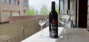 eine Flasche Wein und zwei Weingläser auf einem Tisch in der Unterkunft Fantástico apartamento al lado del Serrallo in Tarragona