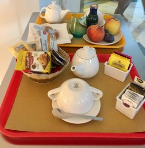 einen Tisch mit zwei Tabletts mit einer Teekanne drauf. in der Unterkunft Residence Alle Scuole Country House in Granarolo dellʼEmilia