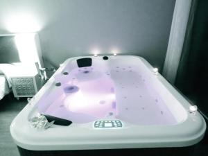 a pink bath tub with lights in a room at Refugio O Castro in Barreiros