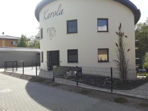 ein weißes Gebäude mit einem Schild an der Seite in der Unterkunft KAMA Ferienhäuser Haus Karola in Wendisch Rietz