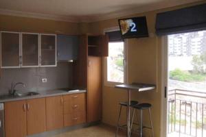 サンタクルス・デ・テネリフェにあるDúplex céntrico en S/Cのキッチン(スツール2脚、壁掛けテレビ付)