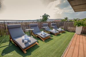 a row of chaise lounge chairs sitting on a lawn at Yosefdream Luxury suites in Had Nes