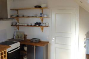 a kitchen with a laptop on a counter and a door at Charming flat in cosy farmhouse in Skudeneshavn