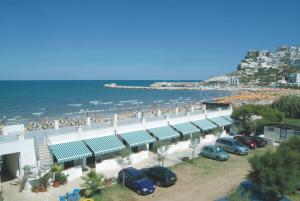 a parking lot next to a beach with cars parked at Villaggio Bellariva in Peschici