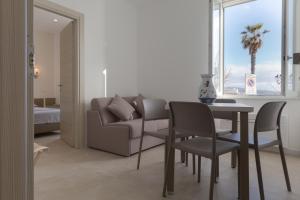 un soggiorno con un divano, un tavolo e delle sedie di Casa Jaume ad Alghero